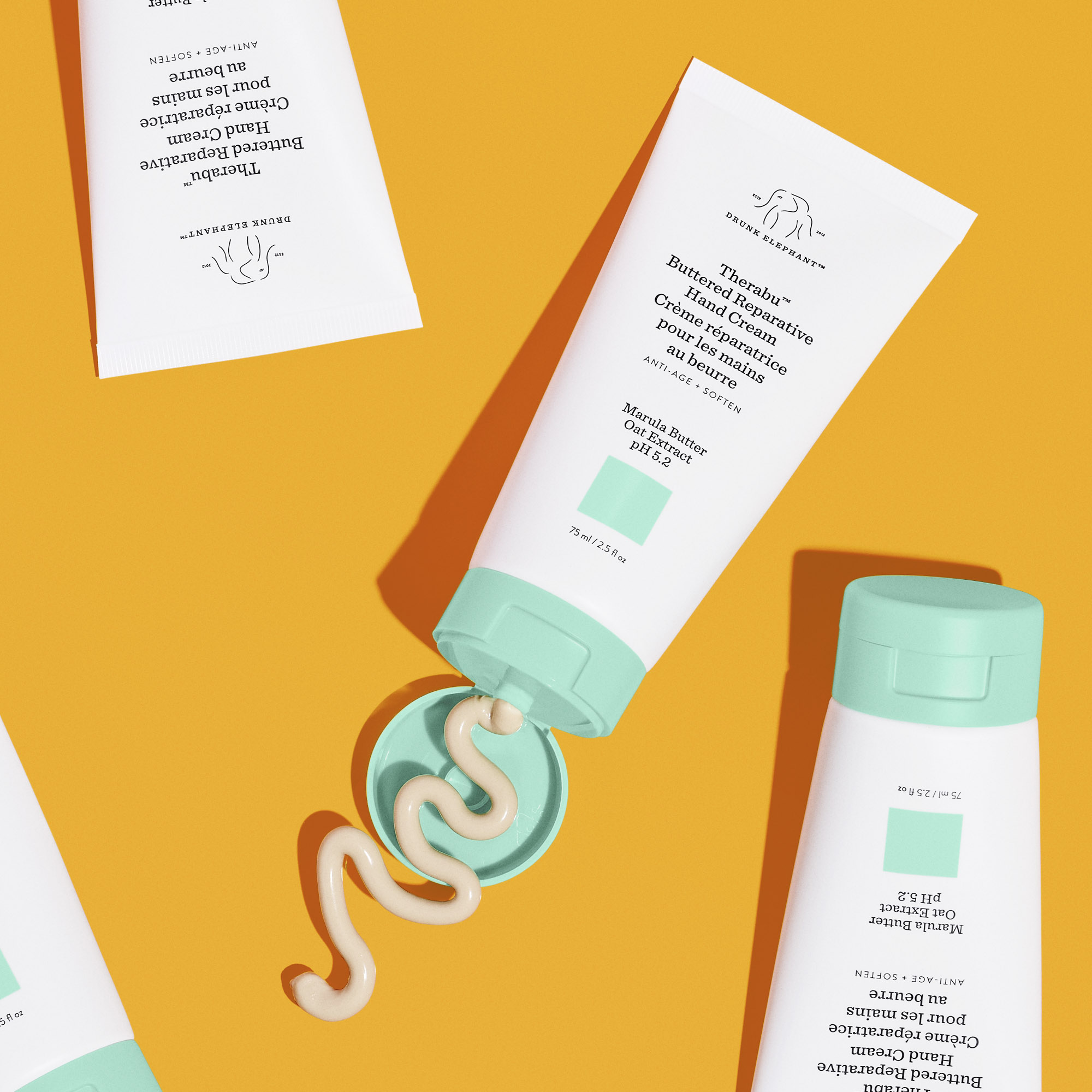 Drunk Elephant Therabu Hand Cream on Orange Background